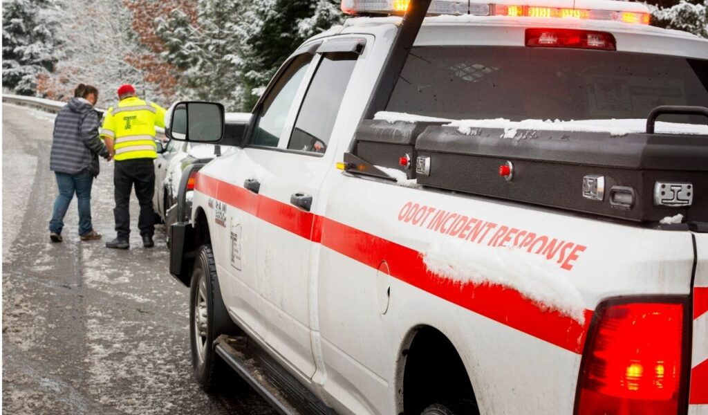 An Oregon Department of Transportation roadside assistance employee assisting a motorist